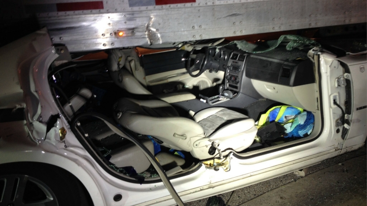 Car runs under trailer of semi truck